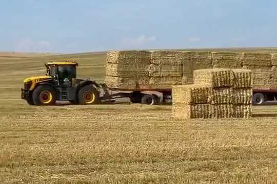 Traktor se soupravou balíků slámy